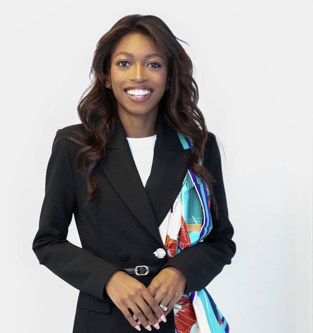 Naledi Ncube smiling in a black blazer with a colourful silk scarf